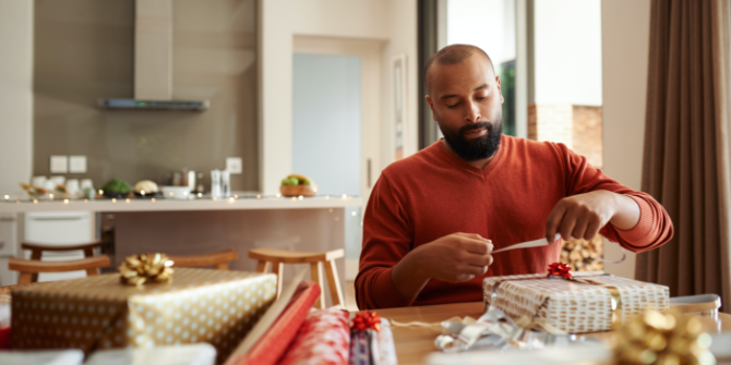 Man wrapping presents for the Holidays