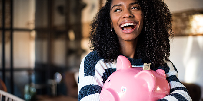 Woman hugging her piggy bank