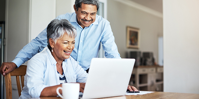 Couple smiling while looking at laptop
