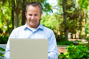 Man in a park with laptop