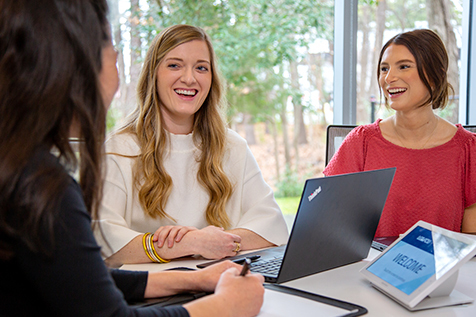 Three women talking around a table.