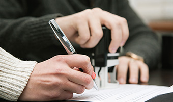 Notary public stamping a document in an office.