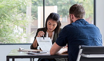 Businesswoman discusses a document with a customer.