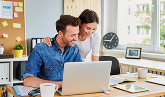 Husband and wife working together at home office.