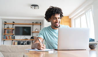 Young man working on laptop at home.