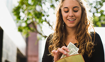 Teen removing money from wallet.