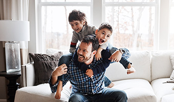 Father happily playing with two young sons.  