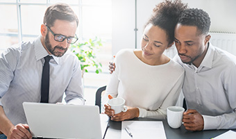 Married couple consults with an advisor on a laptop.