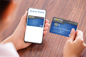 Hand holding mobile phone and hand holding credit card