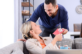 man giving gift envelope to his wife