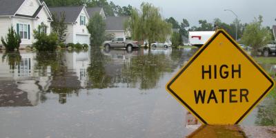 Sign reading high water posted on a flooded street