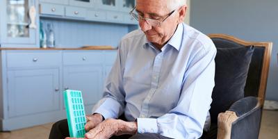 Older man holding medicine container