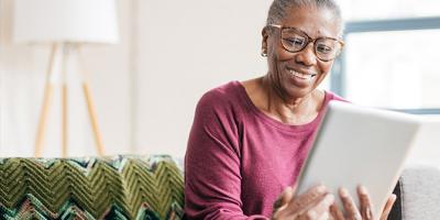 Older woman looking at tablet and smiling