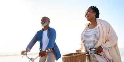 Man and woman riding their bikes at the beach