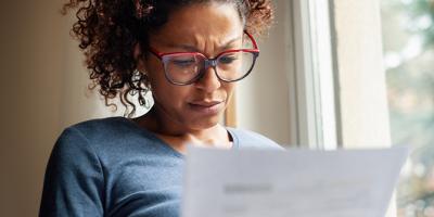 Woman going through bills, looking worried