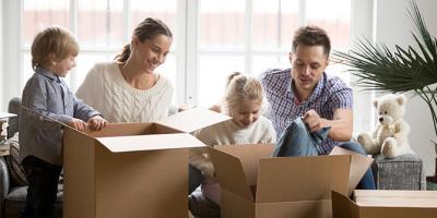 Man, woman and two children packing boxes on moving day.