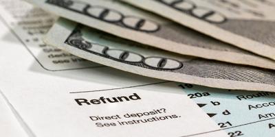 hundred-dollar bills lying on the refund section of a tax form