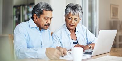 Senior couple using a laptop to review their retirement savings