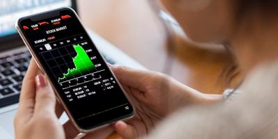 Person analyzing financial charts on cell phone