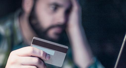 Worried man holding credit card