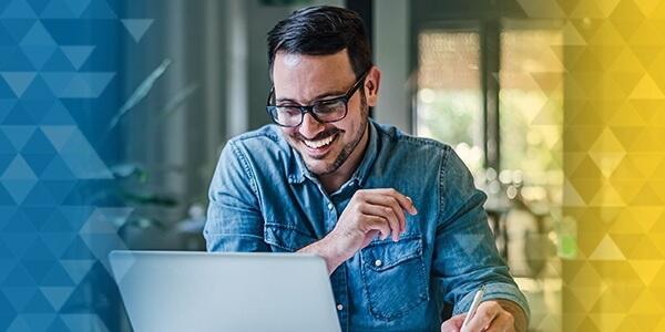 Man on laptop smiling at what he sees on the screen.