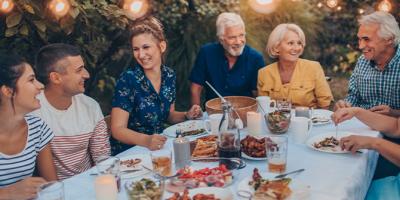 Multi-generation family having dinner in the backyard